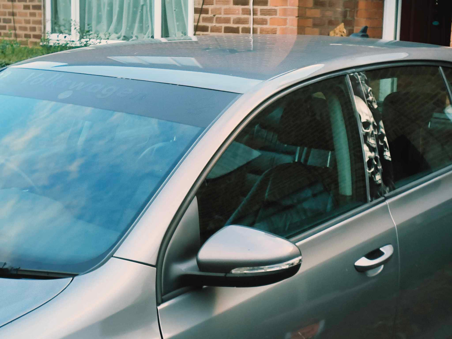 Side view of a car with a visible brand logo, parked outdoors.
