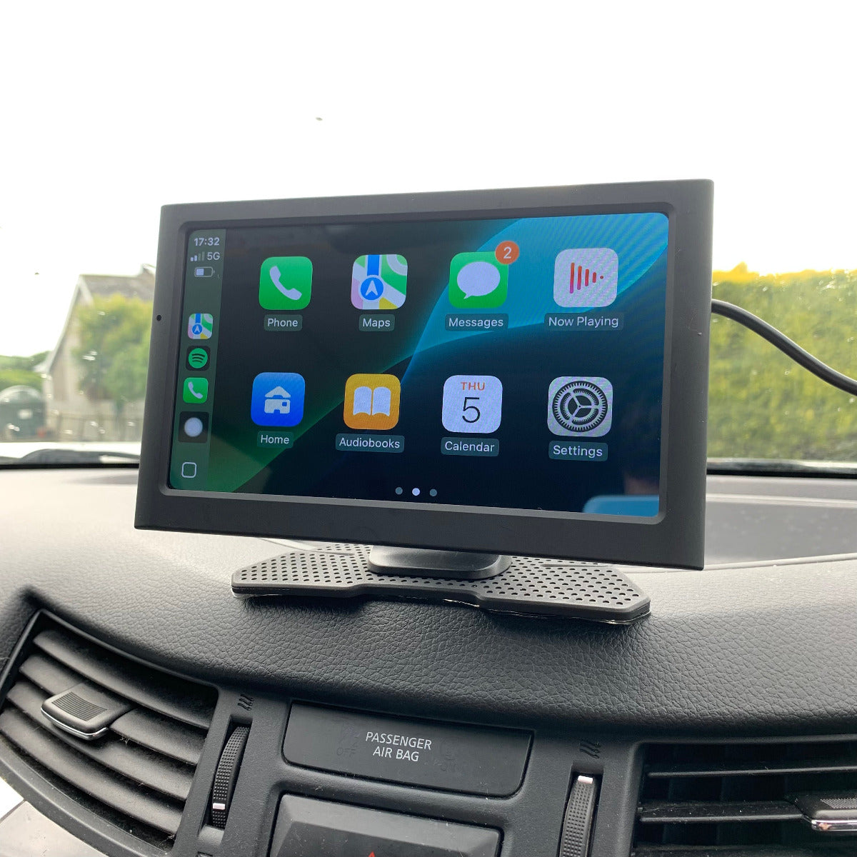 Car dashboard with a mounted tablet displaying app icons