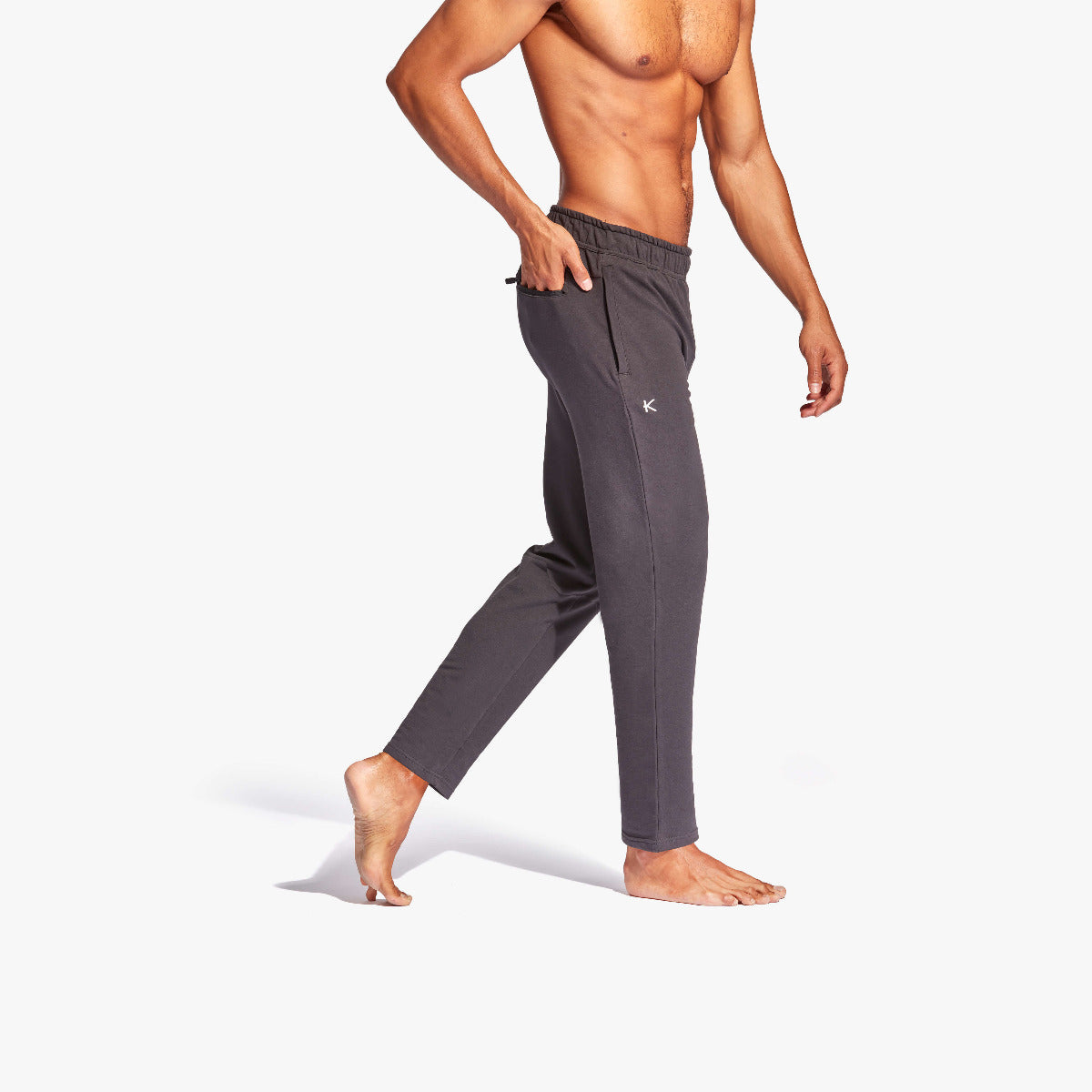 Person wearing gray jogger pants on a white background