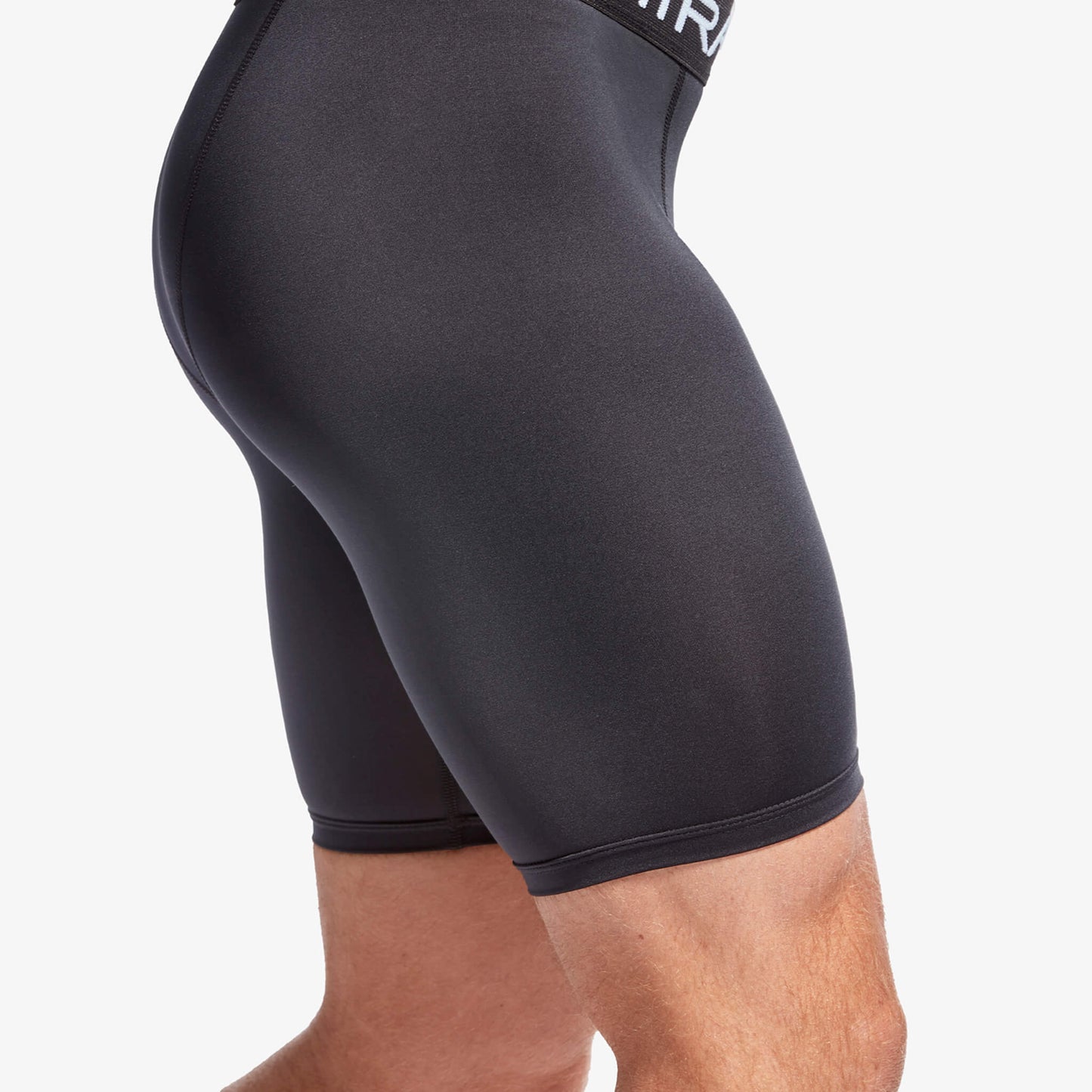Black athletic shorts on a person against a white background