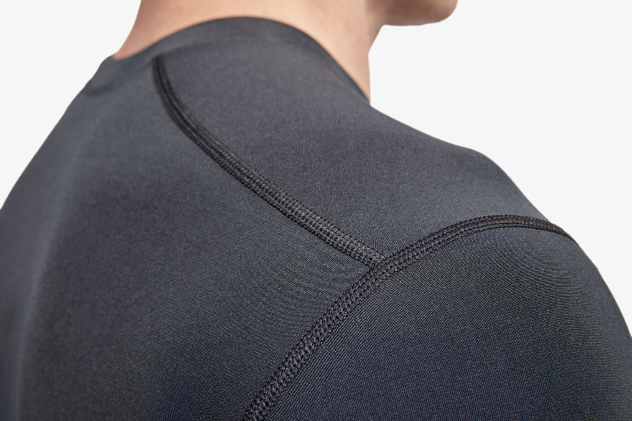 Close-up of a person wearing a dark gray athletic shirt with a focus on the shoulder area.