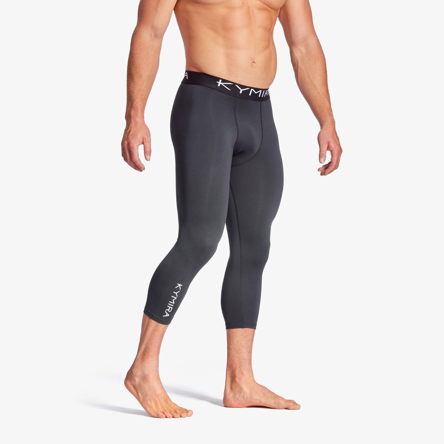 Person wearing black compression leggings with a brand logo on a white background