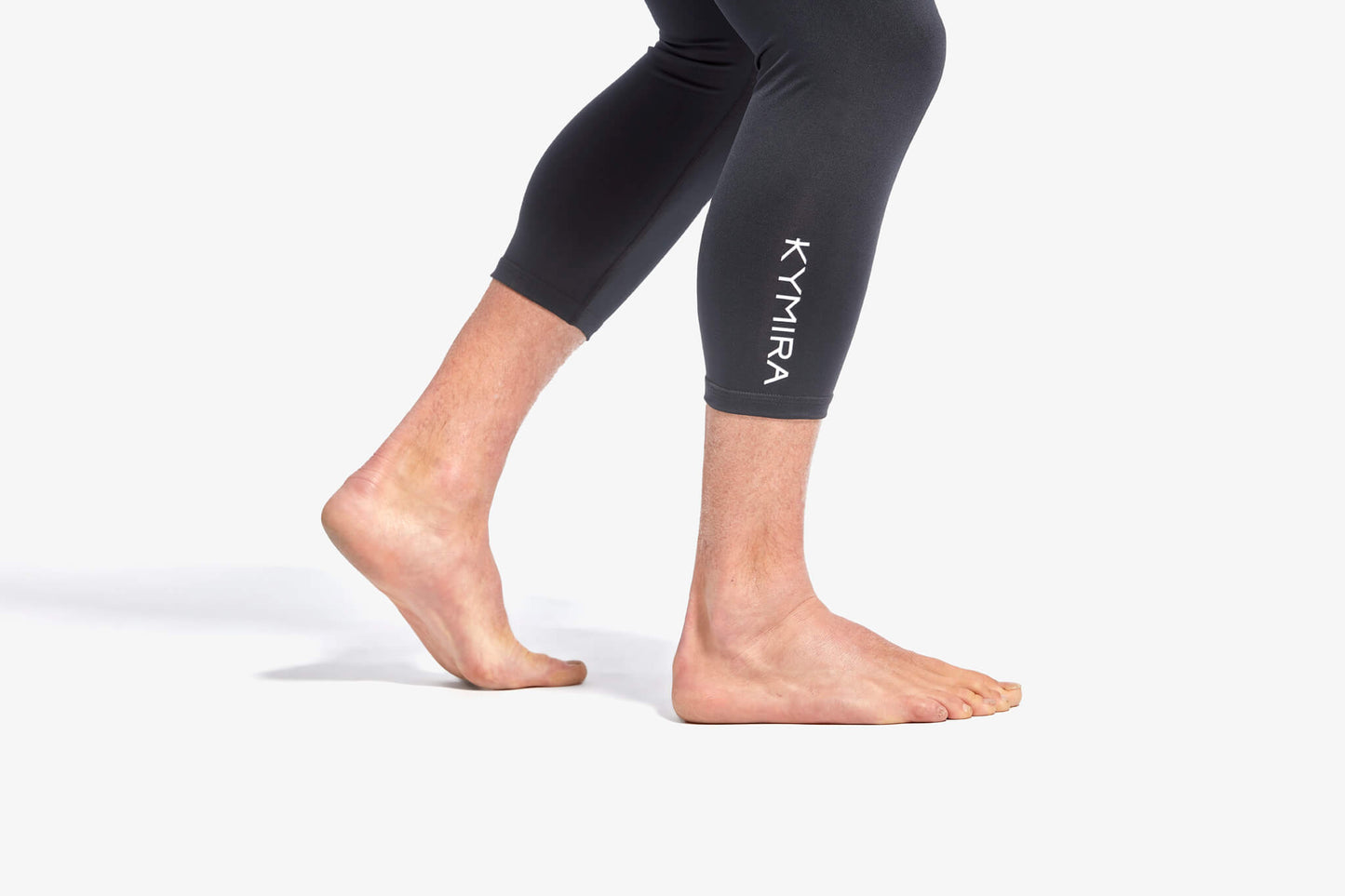Person wearing black leggings with 'Kymira' logo on a white background