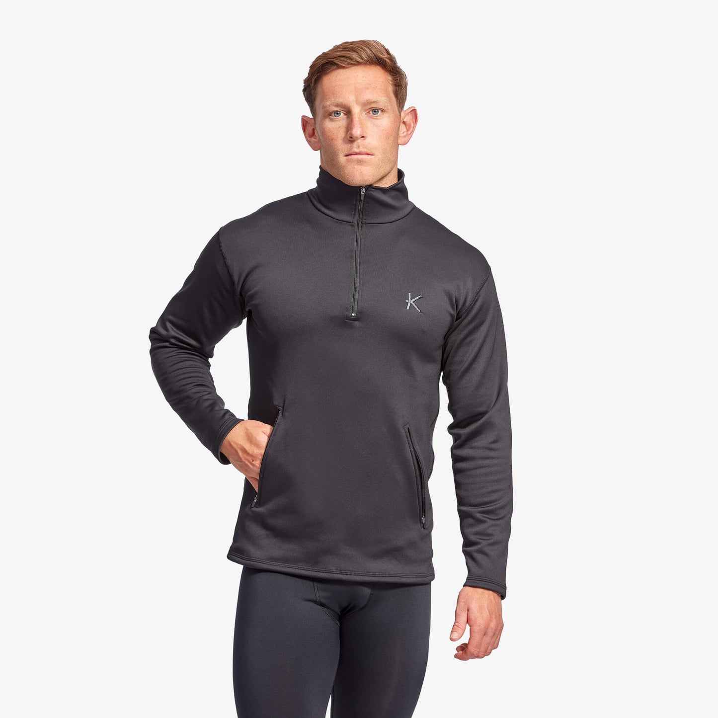 Man wearing a dark gray long-sleeve athletic shirt with a logo on a white background