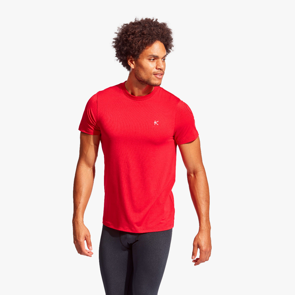 Man wearing a red athletic shirt with a logo on a white background