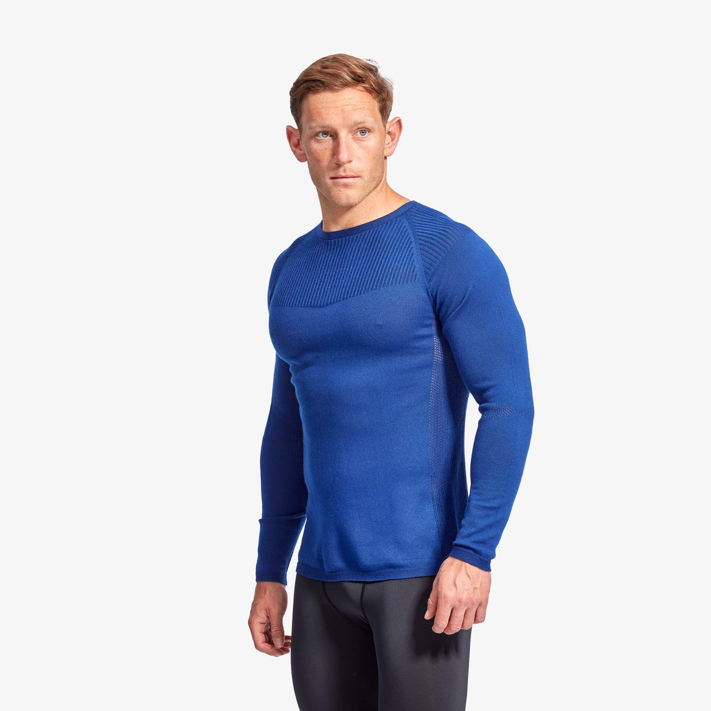 Man wearing a blue long-sleeve athletic shirt on a white background