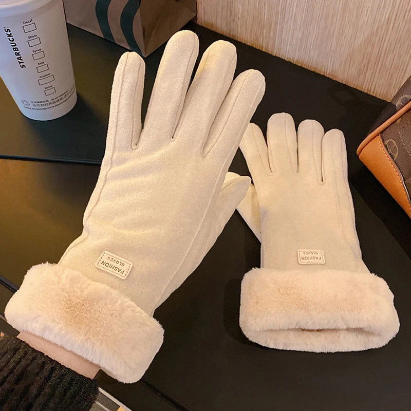 Pair of white gloves with fur cuff on a dark surface, next to a Starbucks cup.