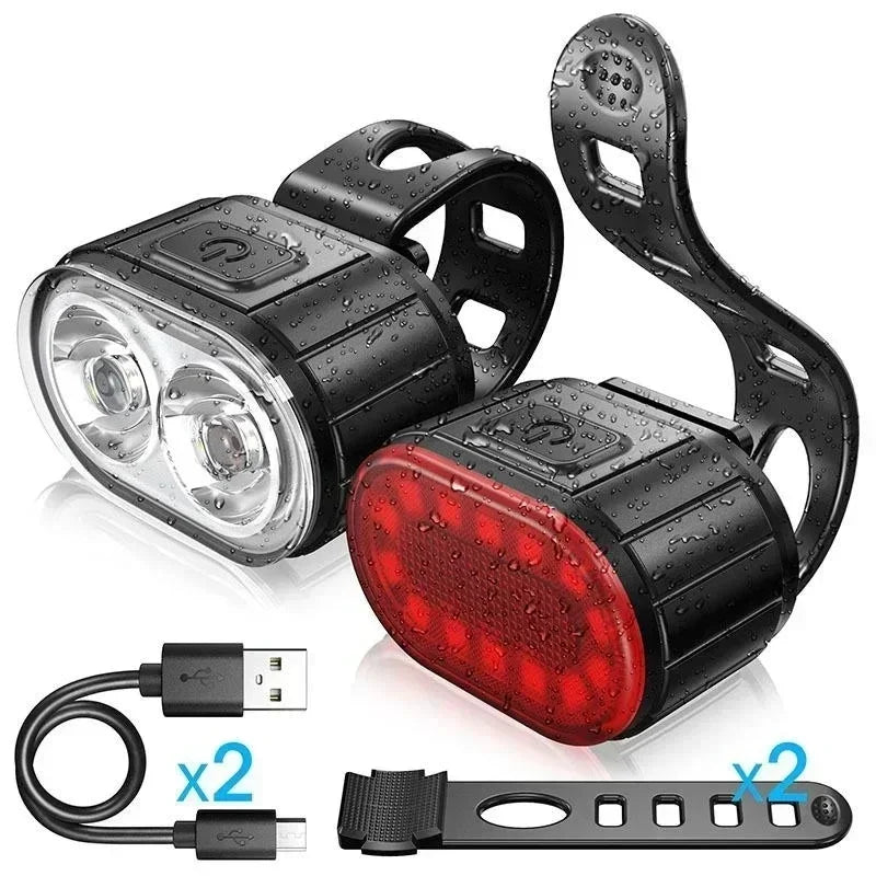 Bicycle lights set with front and rear lights, USB cable, and reflectors on a white background
