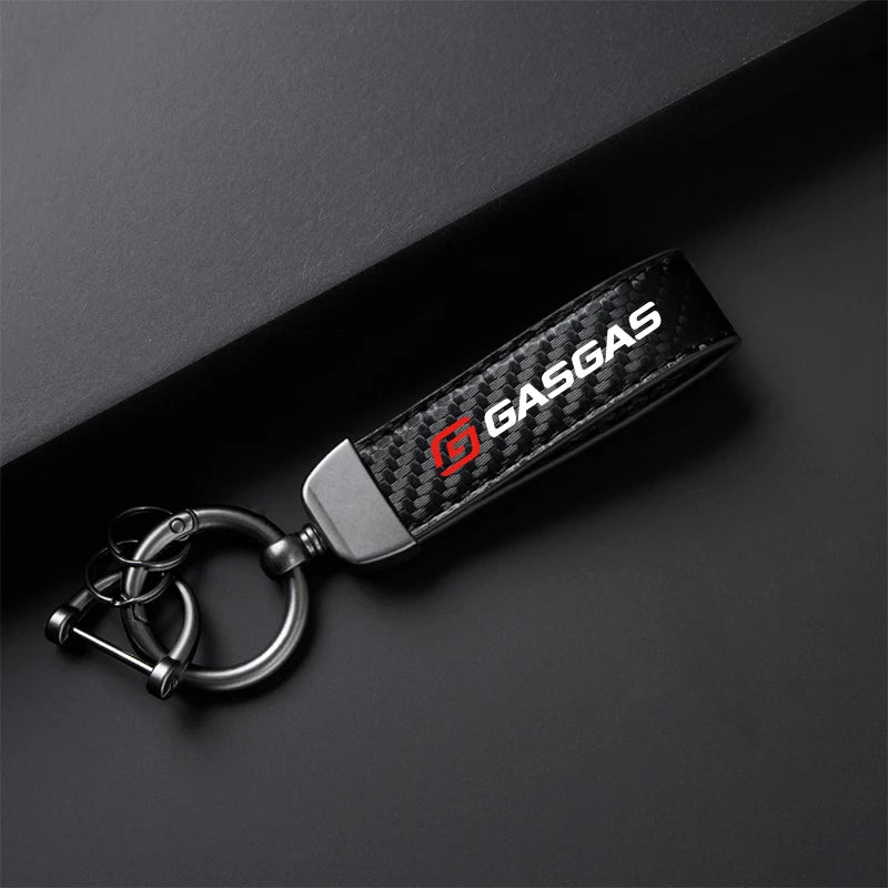 Carbon fiber keychain with 'GASGAS' logo on a dark background