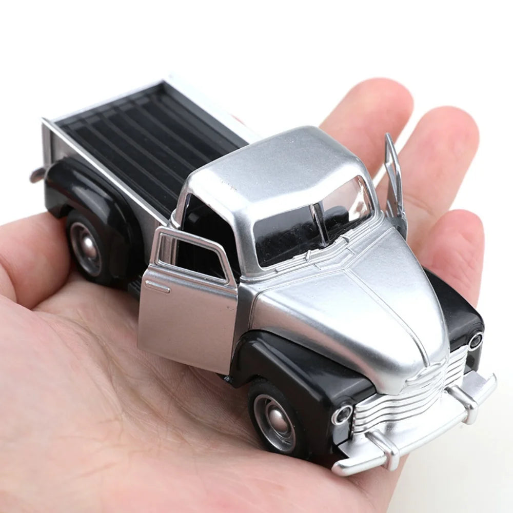 Small model of a classic truck held in a hand against a white background