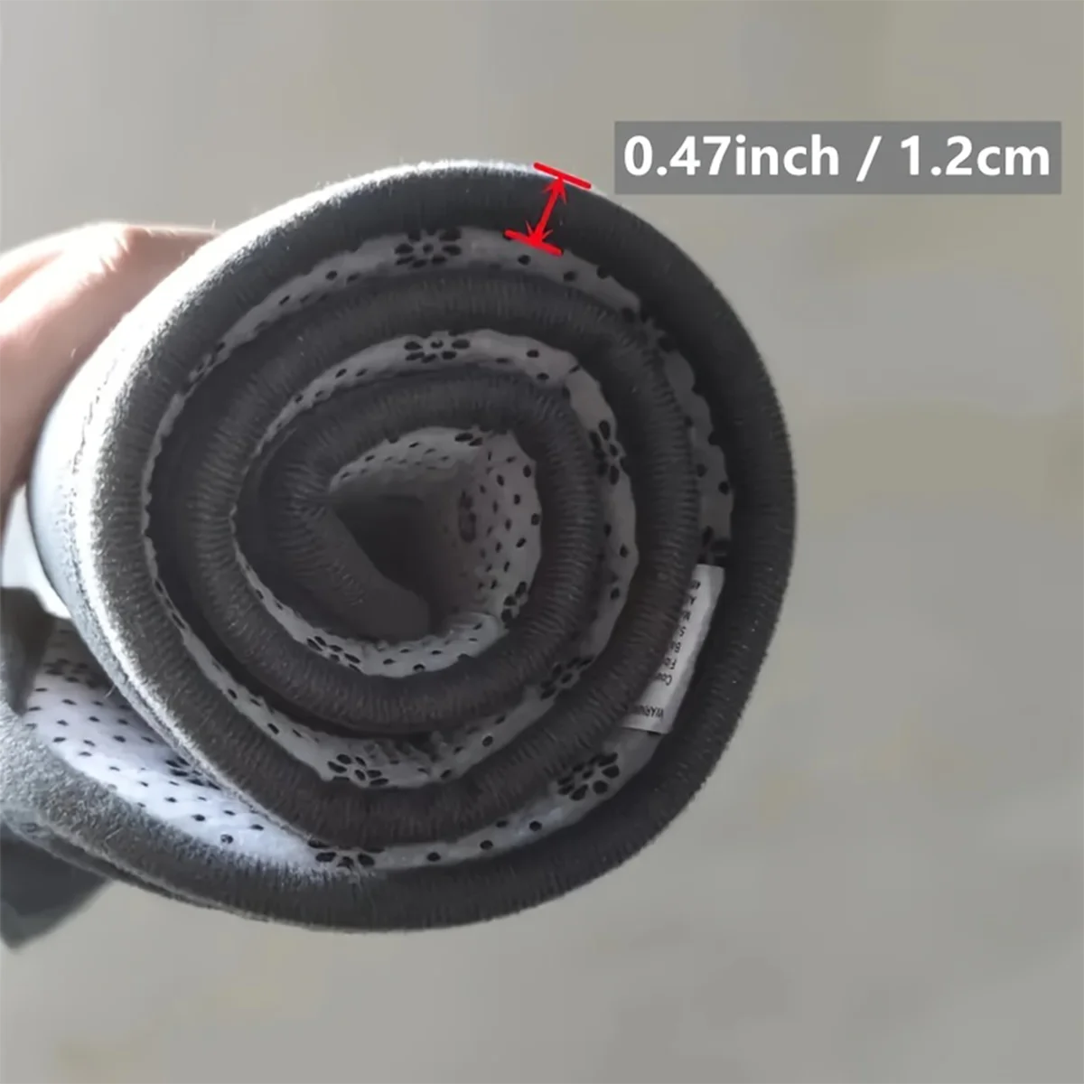 Coiled black filter with measurement label on a light background