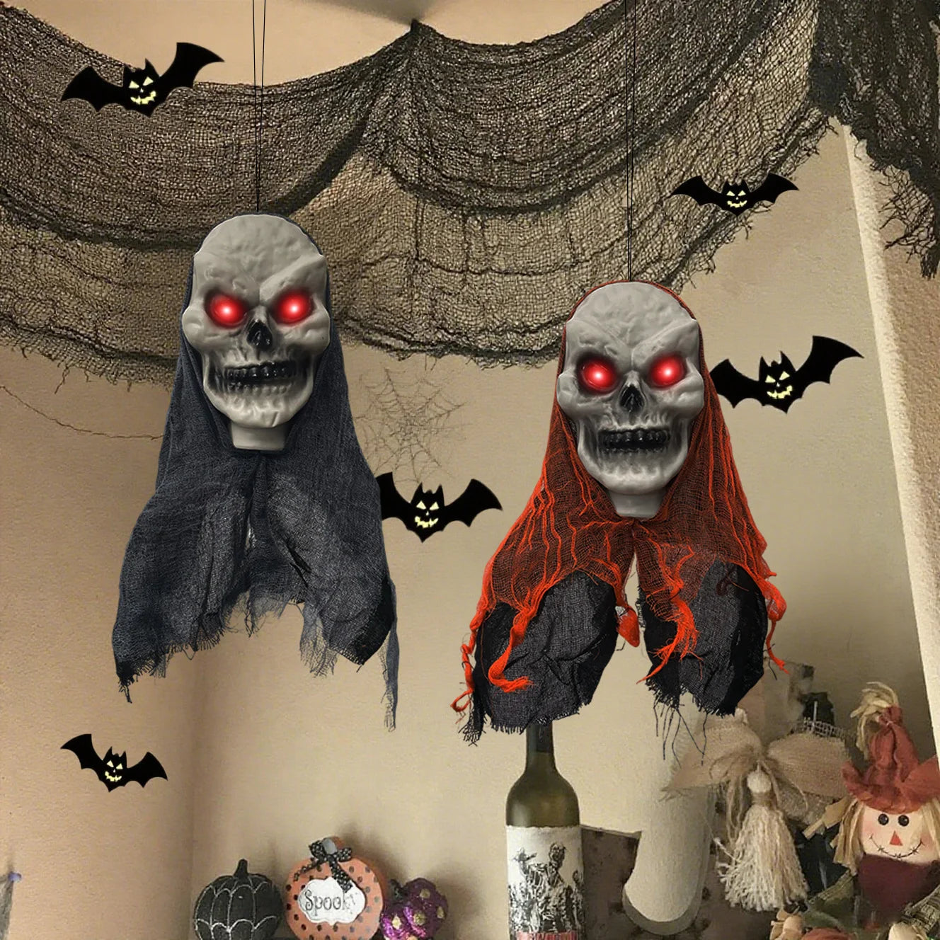 Halloween-themed decorations with ghost heads, bats, and a bottle on a neutral background.