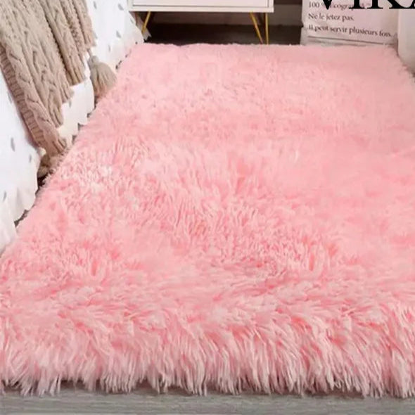 Pink fluffy rug on a wooden floor