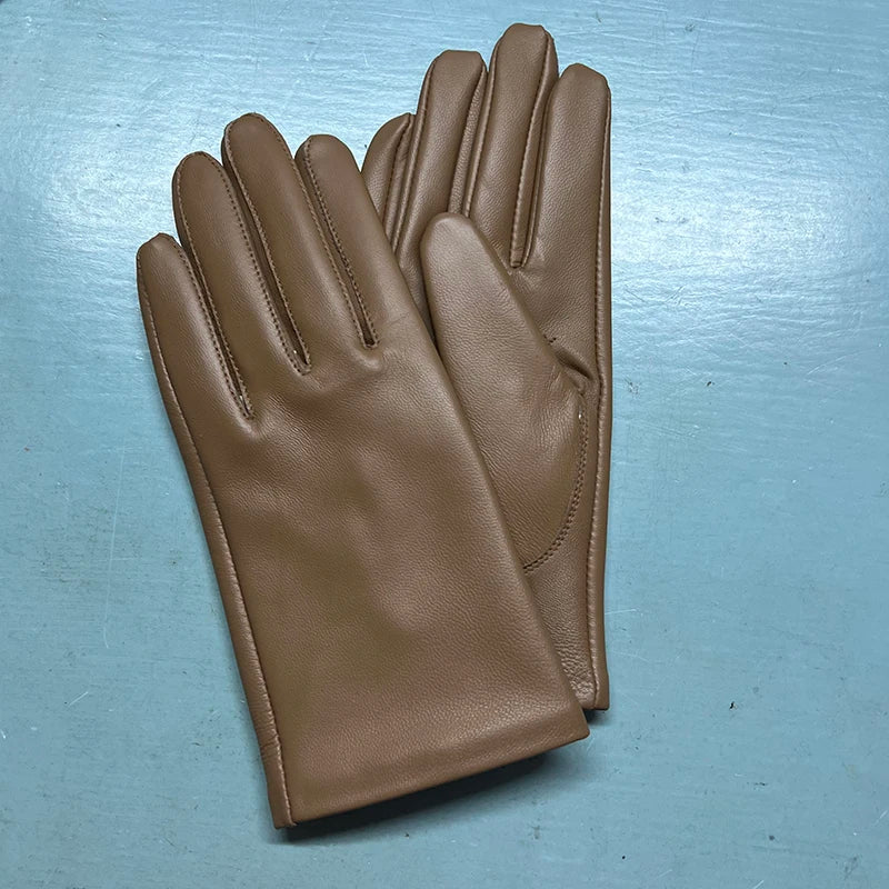 Pair of brown leather gloves on a metallic surface