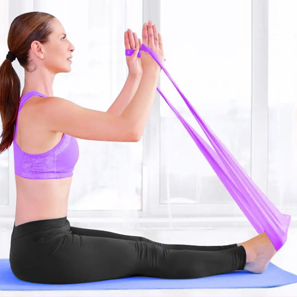 Woman using a resistance band for stretching exercise on a white background