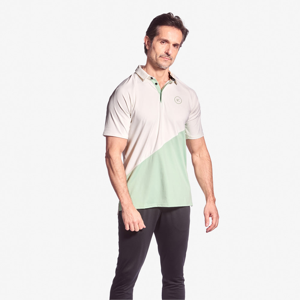 Man wearing a two-tone polo shirt with a white and green design on a white background