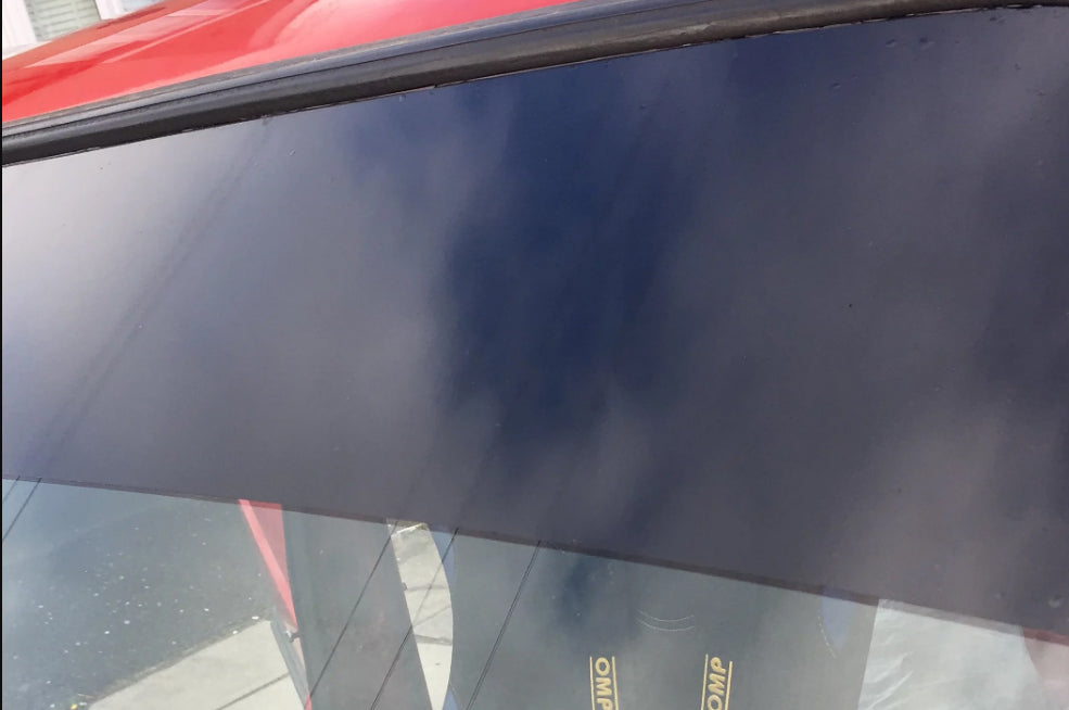 Close-up of a car's windshield with a sun strip