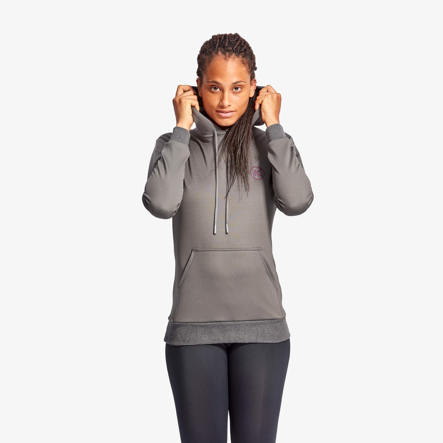 Person wearing a gray hoodie with a small logo on a white background