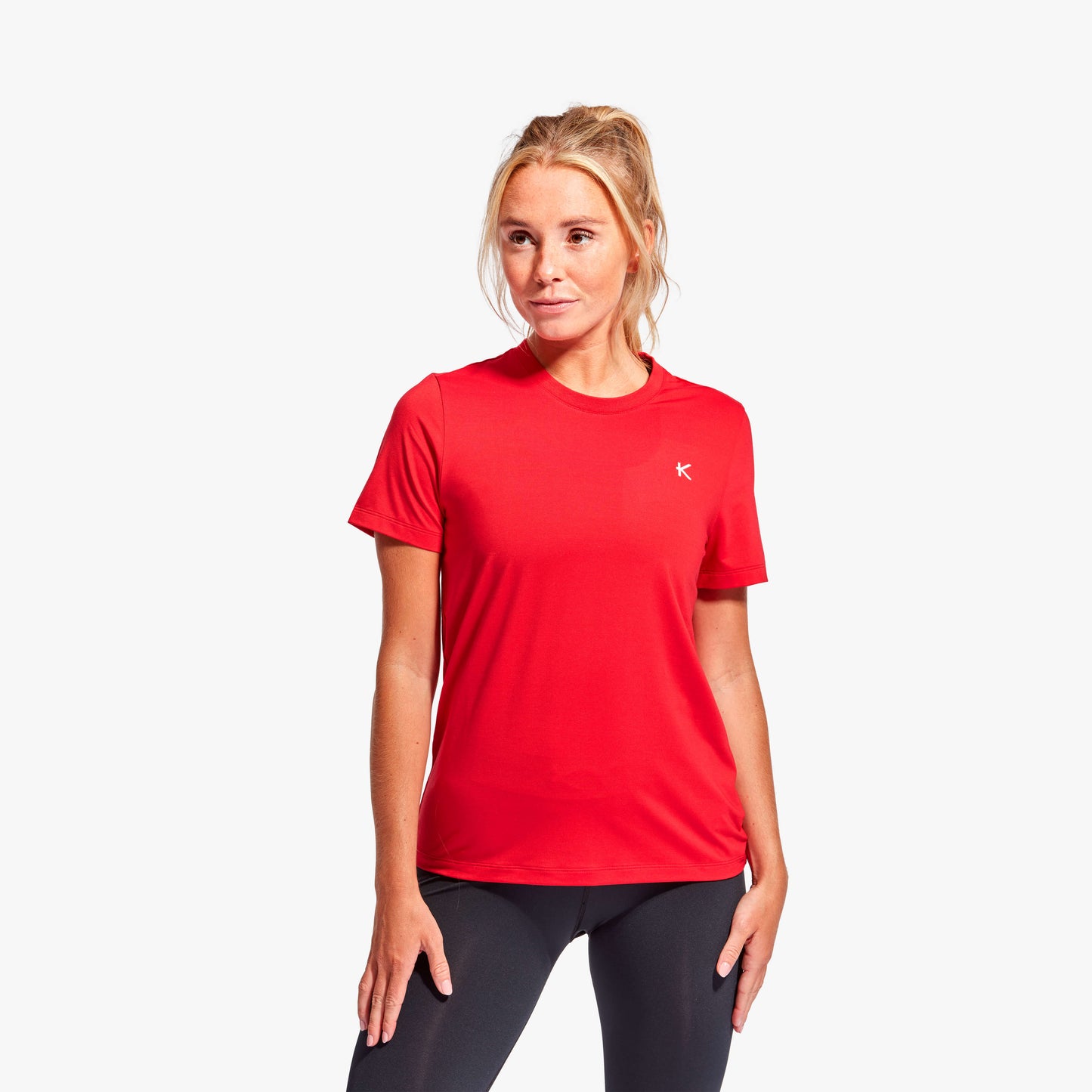 Woman wearing a red athletic shirt with a logo on a white background