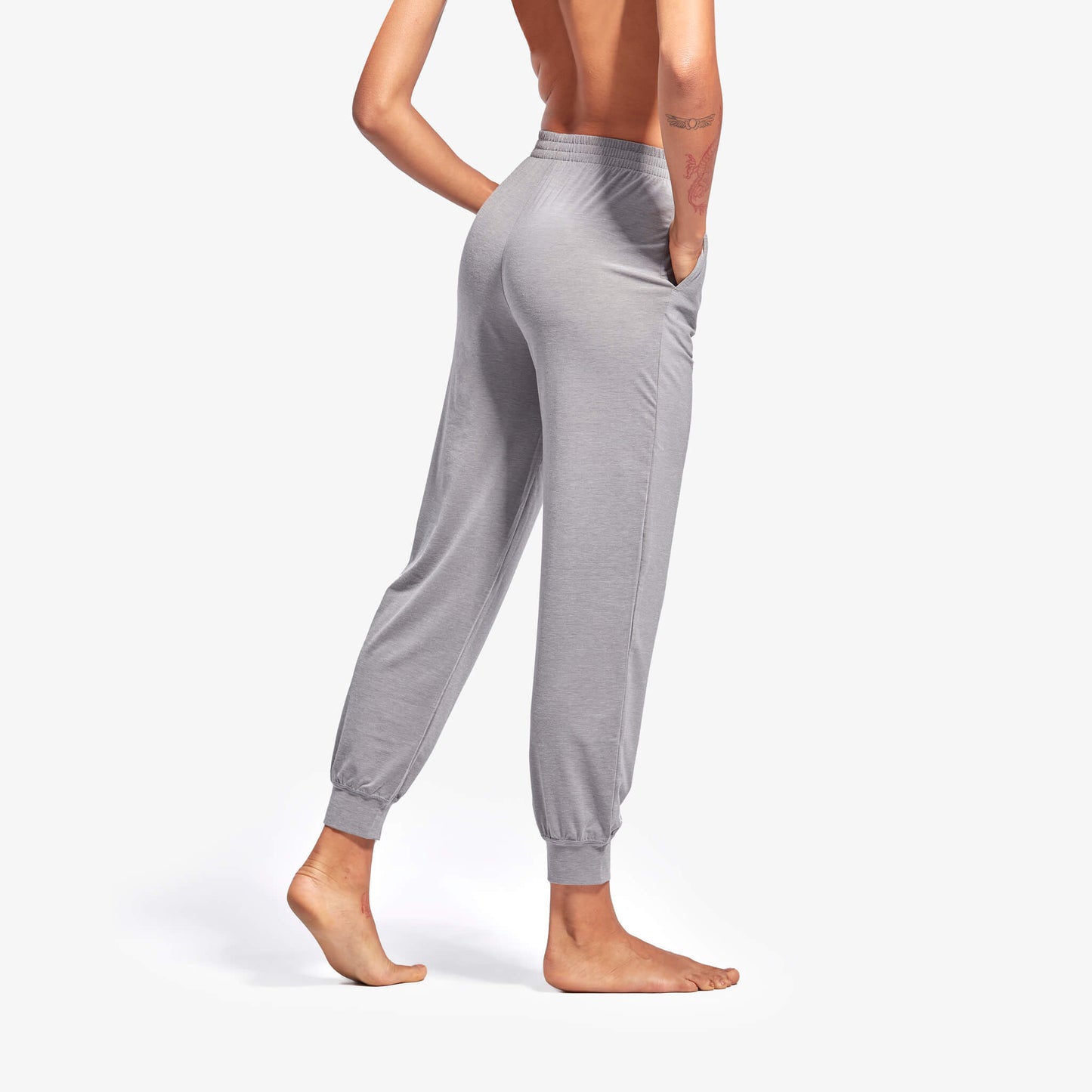 Gray sweatpants worn by a person on a white background
