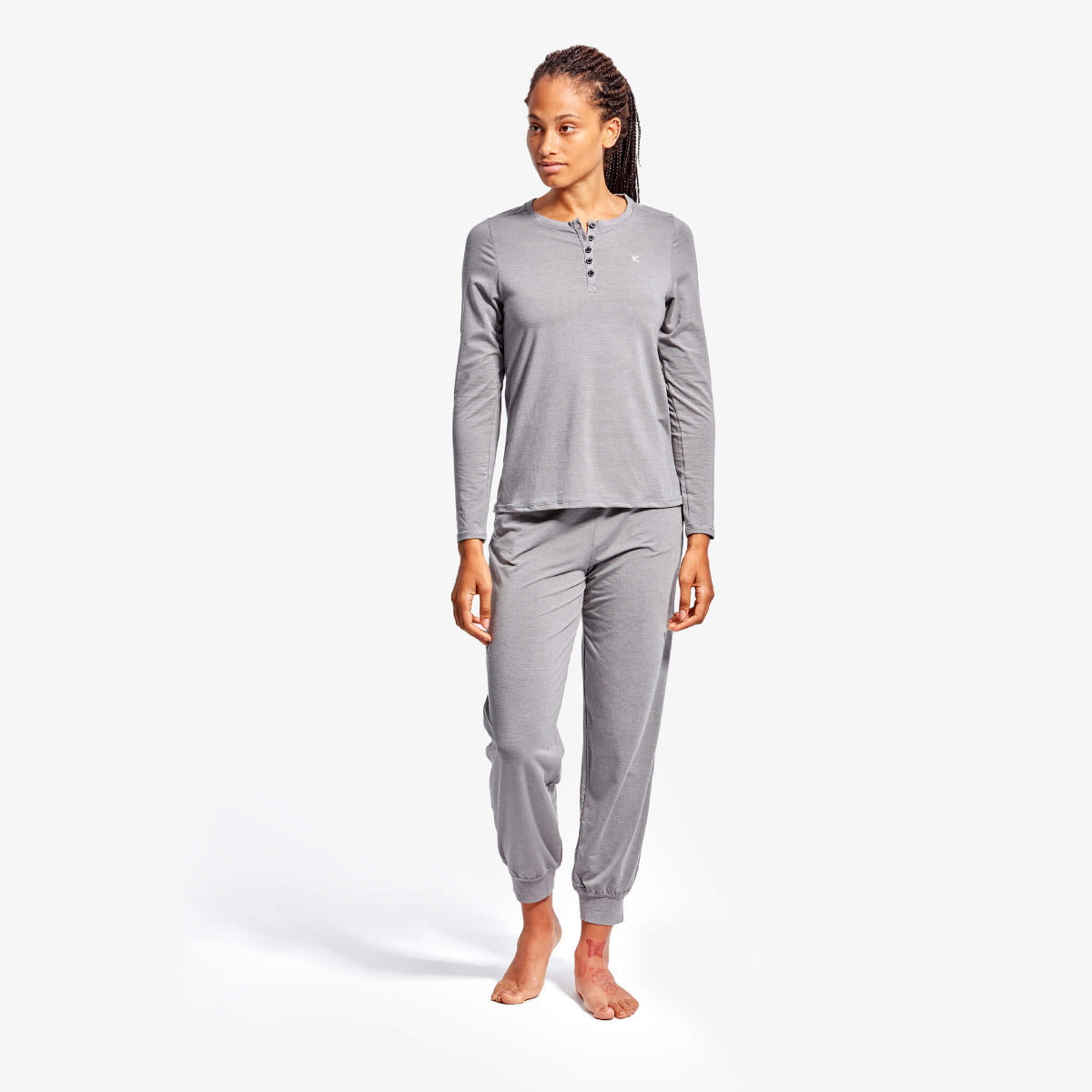 Woman wearing gray pajama set on a white background