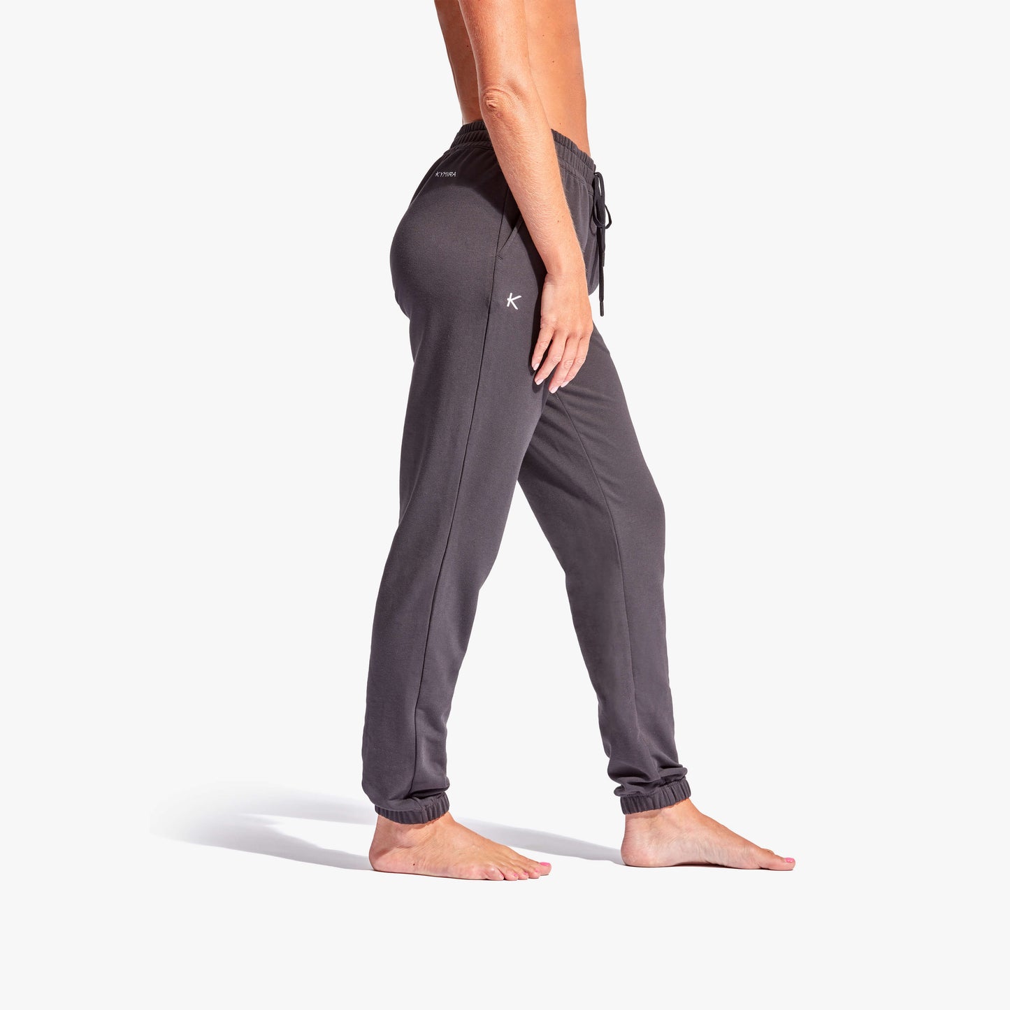 Person wearing gray sweatpants on a white background