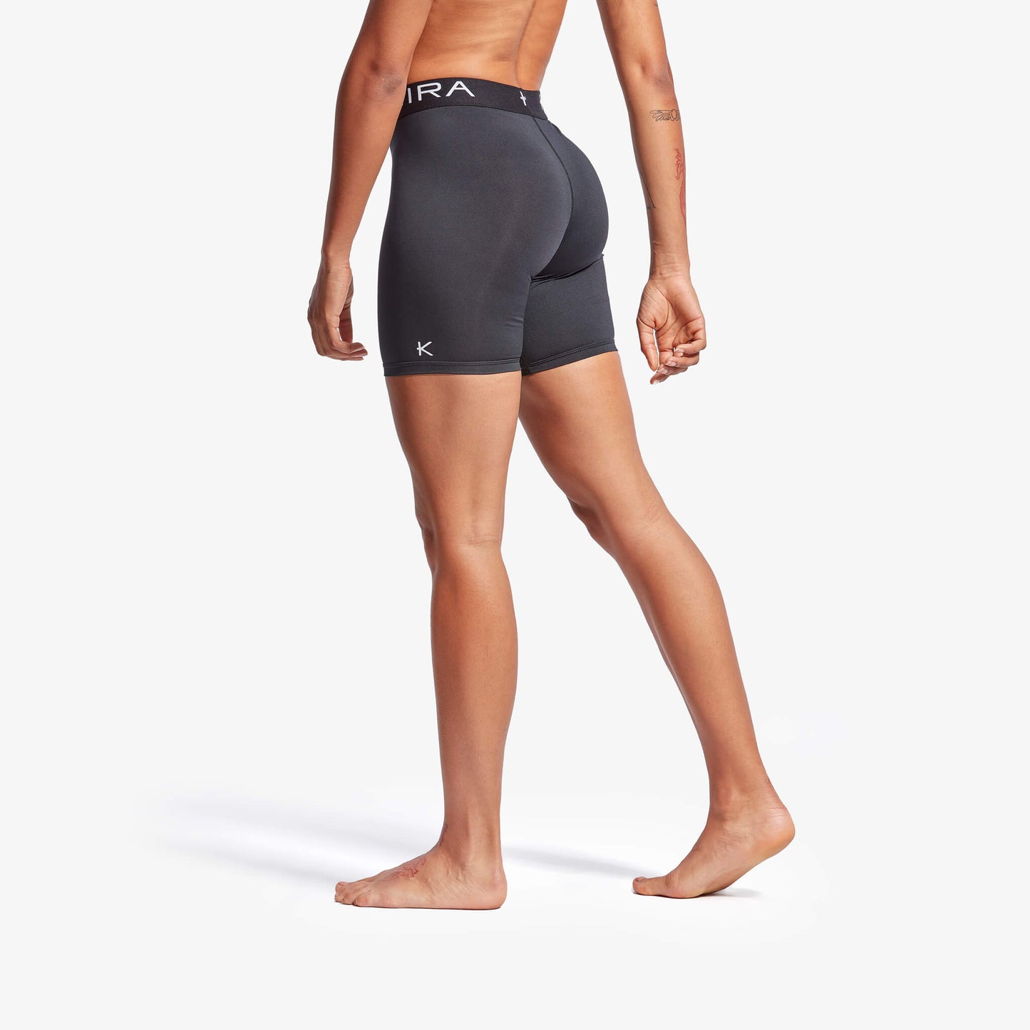 Person wearing black athletic shorts on a white background