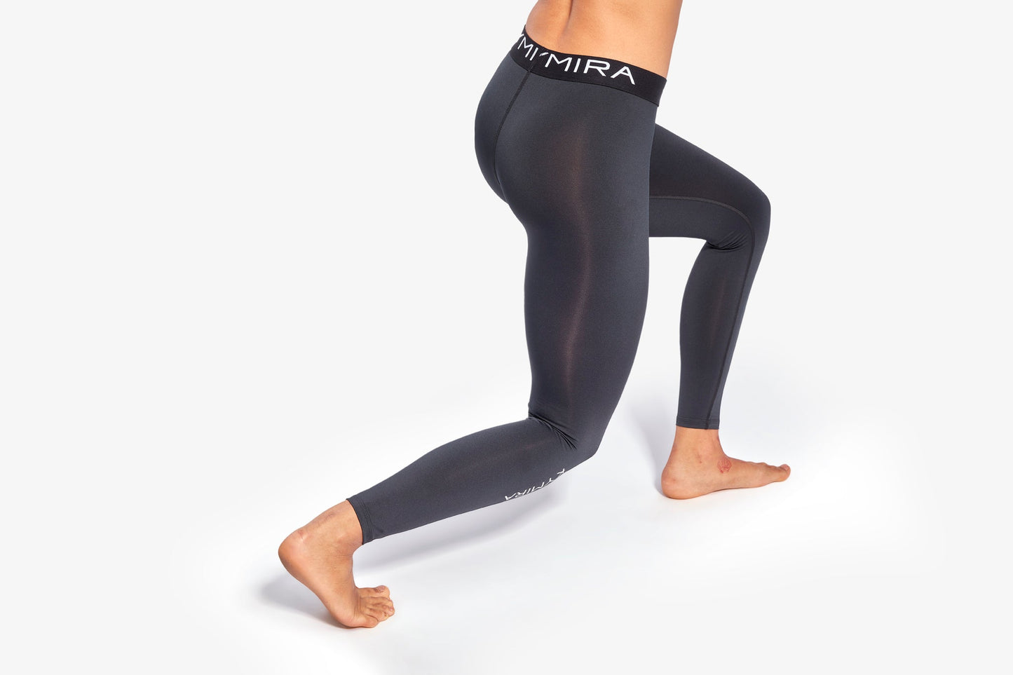 Person wearing black leggings with 'MIRA' branding on a white background