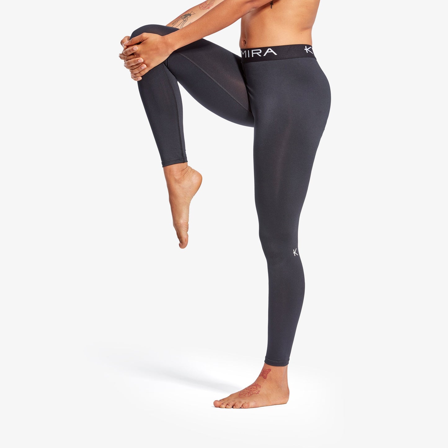 Person wearing black leggings with 'Kima' branding on a white background