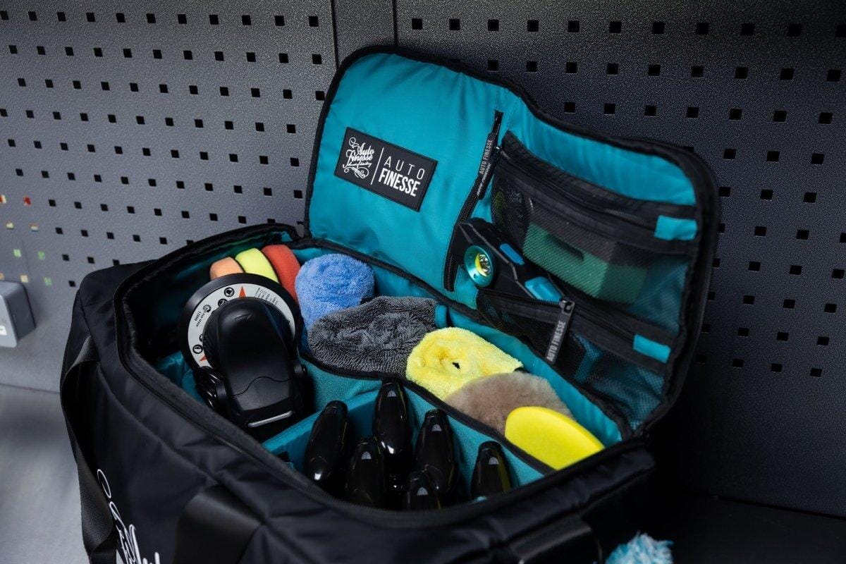 Open tool bag with various tools and a visible brand logo on a pegboard background