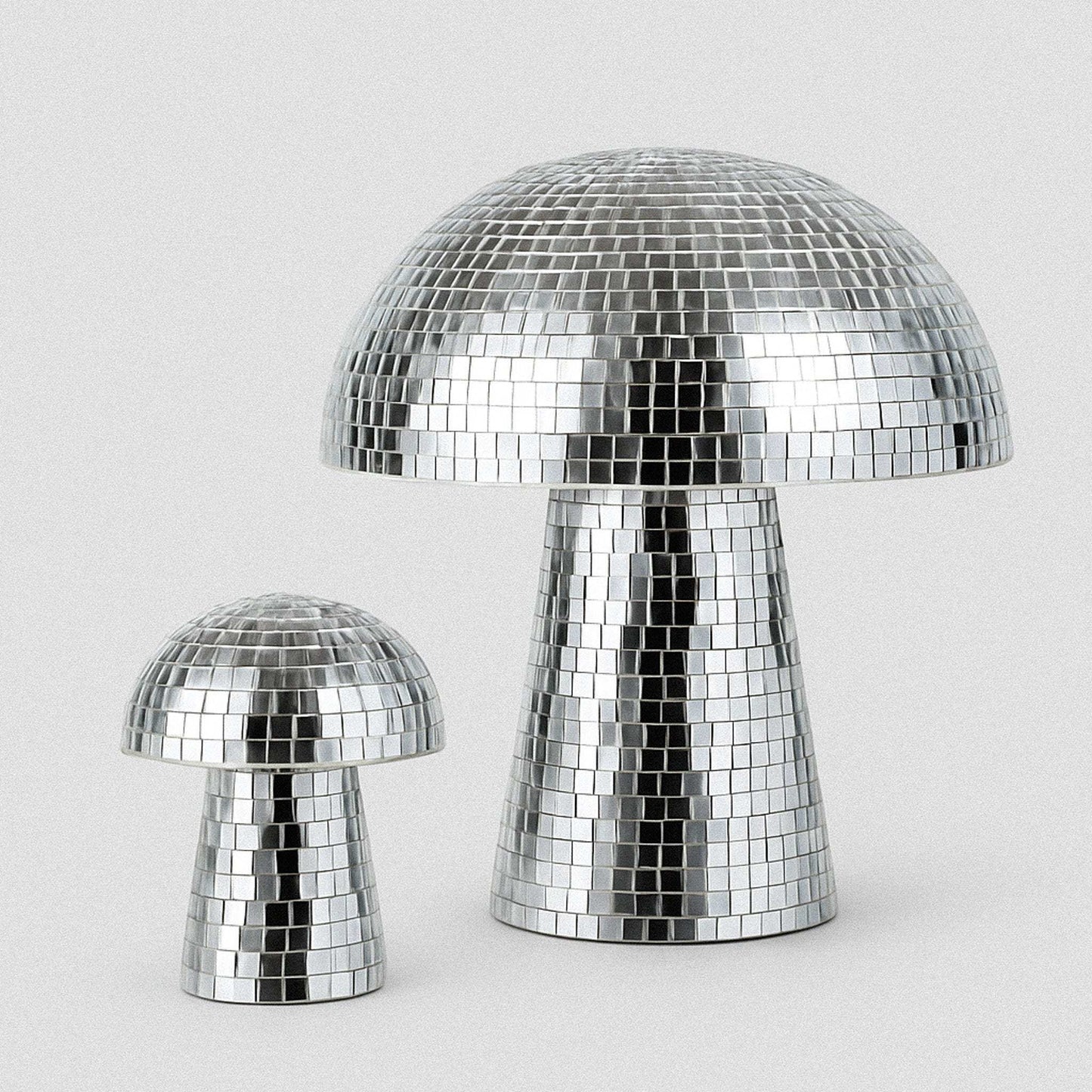 Two silver disco mushroom lamps on a light gray background