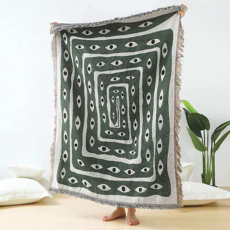 Decorative throw blanket with eye pattern on a white background