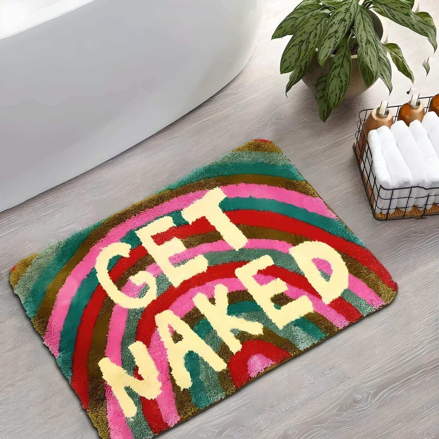 Colorful bath mat with 'GET NAKED' text on a wooden floor.