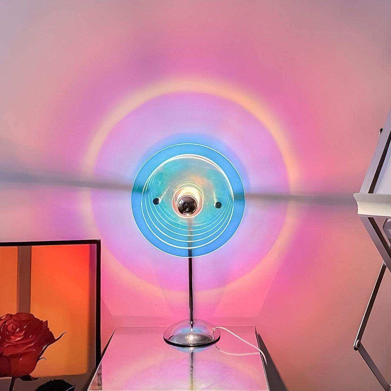 Colorful circular light fixture casting a rainbow pattern on a wall with a red rose in the foreground.