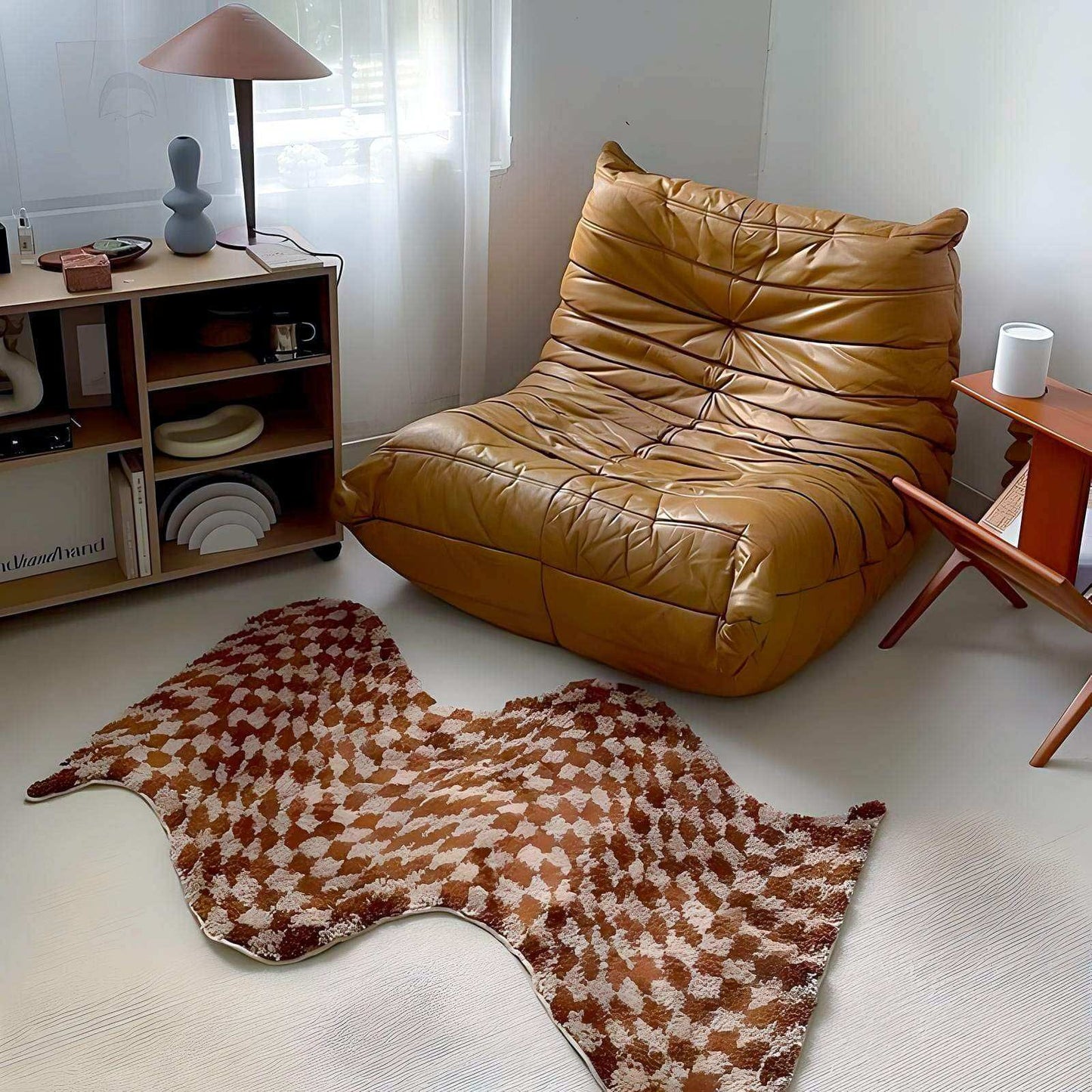 Brown leather lounge chair in a room with a patterned rug and shelves.