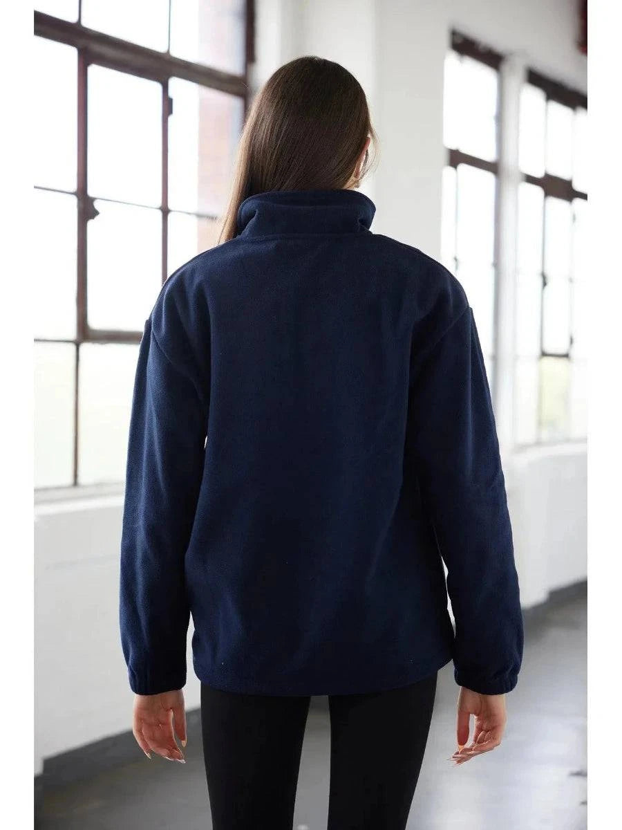 Person wearing a navy blue jacket in a room with large windows.