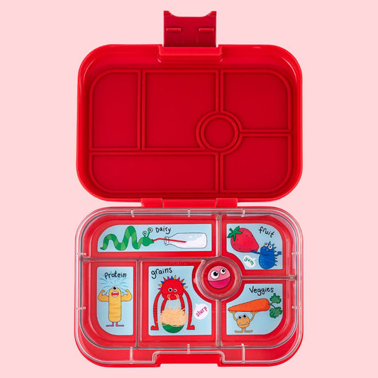 Red lunch box with compartments and cartoon illustrations on a pink background