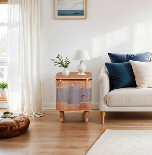 Living room with a wooden side table, white lamp, and beige sofa with blue pillows.