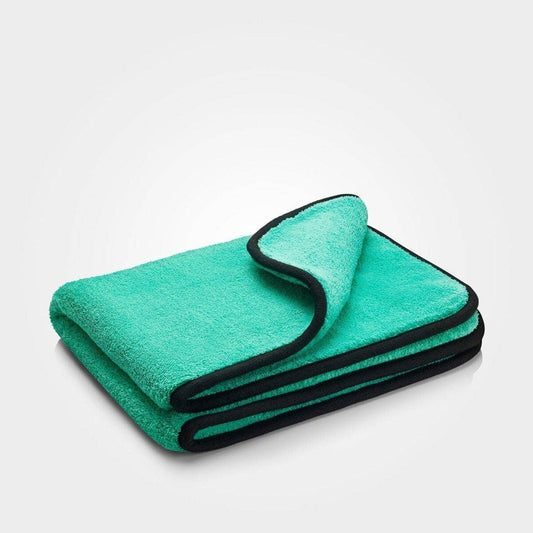 Folded green towel with black border on a white background