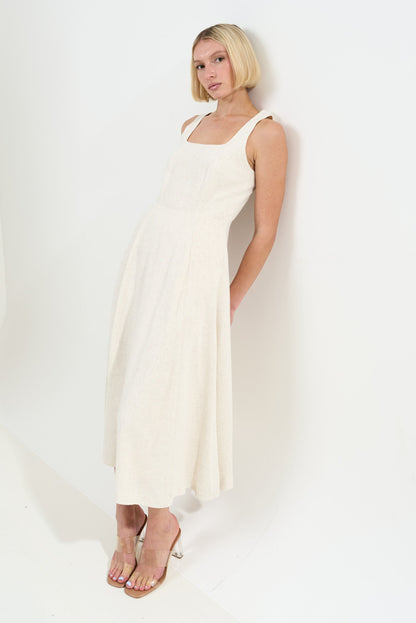 Woman wearing a white sleeveless dress against a white background