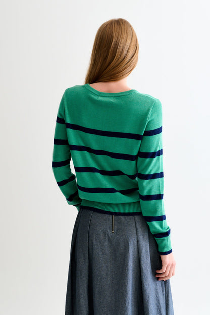 Person wearing a green sweater with black stripes from behind on a light gray background
