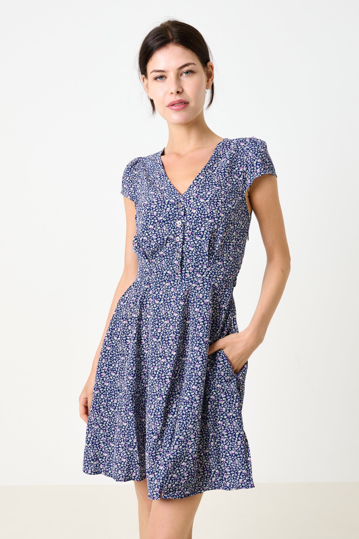 Woman wearing a blue floral dress on a white background