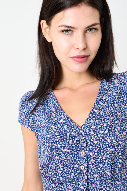 Woman wearing a blue floral dress against a white background