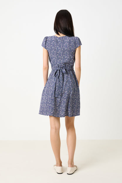 Woman wearing a blue floral dress on a white background