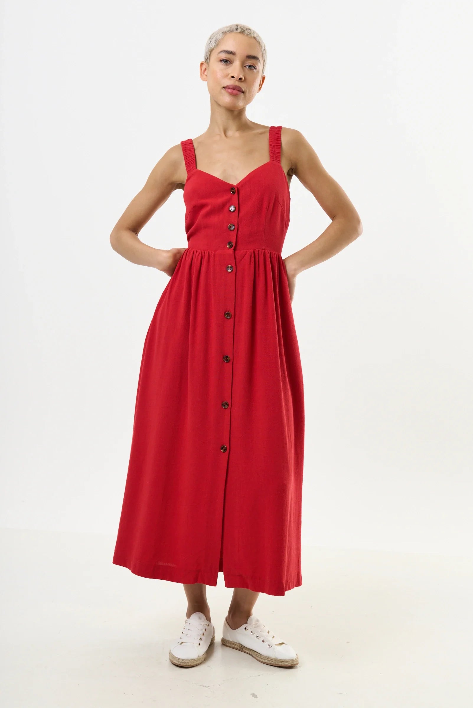 Woman wearing a red dress with buttons on a white background