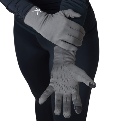 Gray gloves worn by a person against a black background