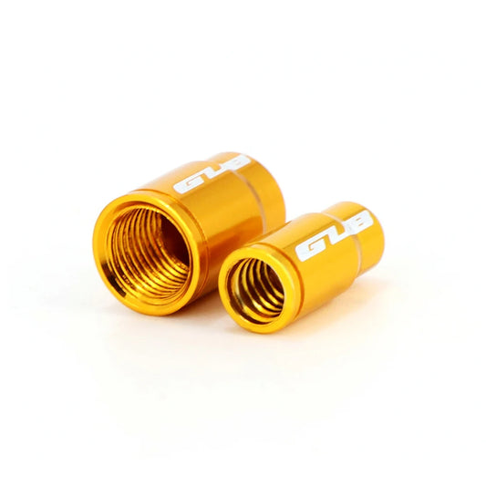 Two gold metal valve stem caps with 'GUB' branding on a white background