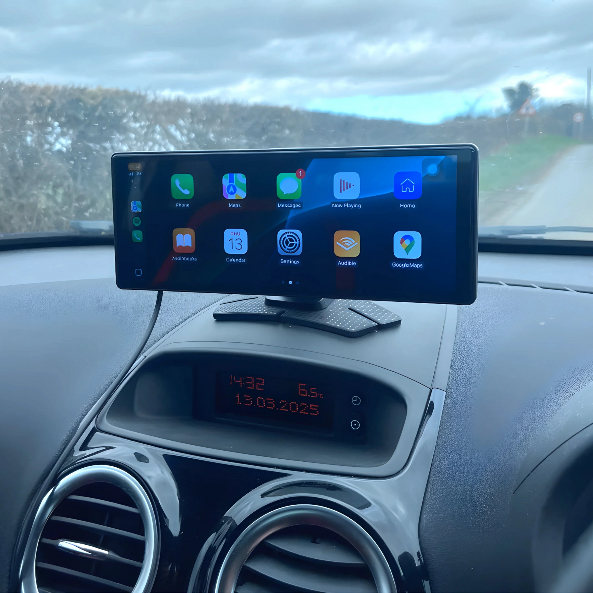 SmartDash device on a car dashboard with a road and trees in the background