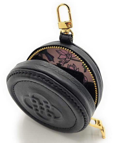 Black round pouch with floral design on flap and gold zipper, on a white background