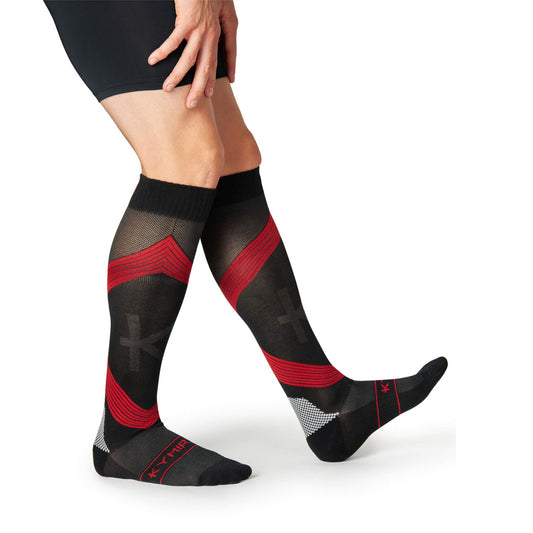 Black and red striped knee-high socks worn by a person on a white background